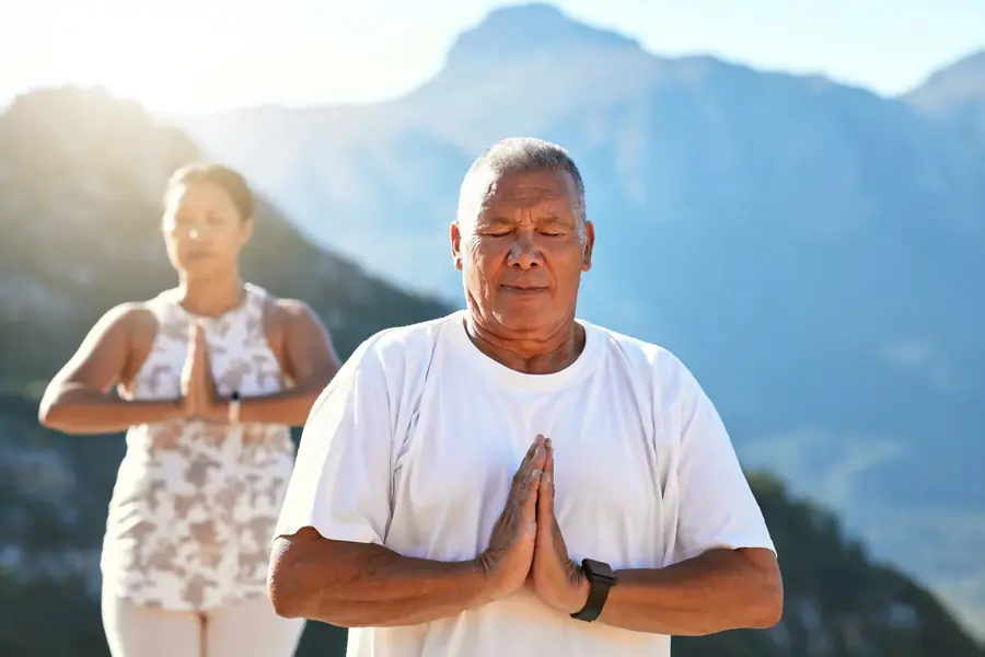 Personas meditando al aire libre en la montaña